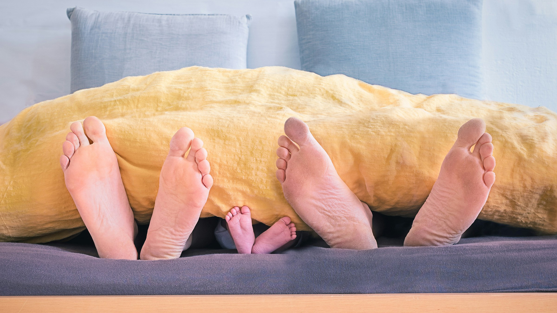 Pies desnudos en la cama